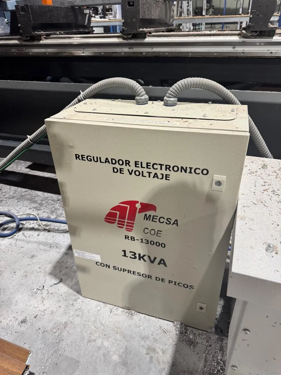 Regulador electrónico de voltaje instalado junto a equipo de producción