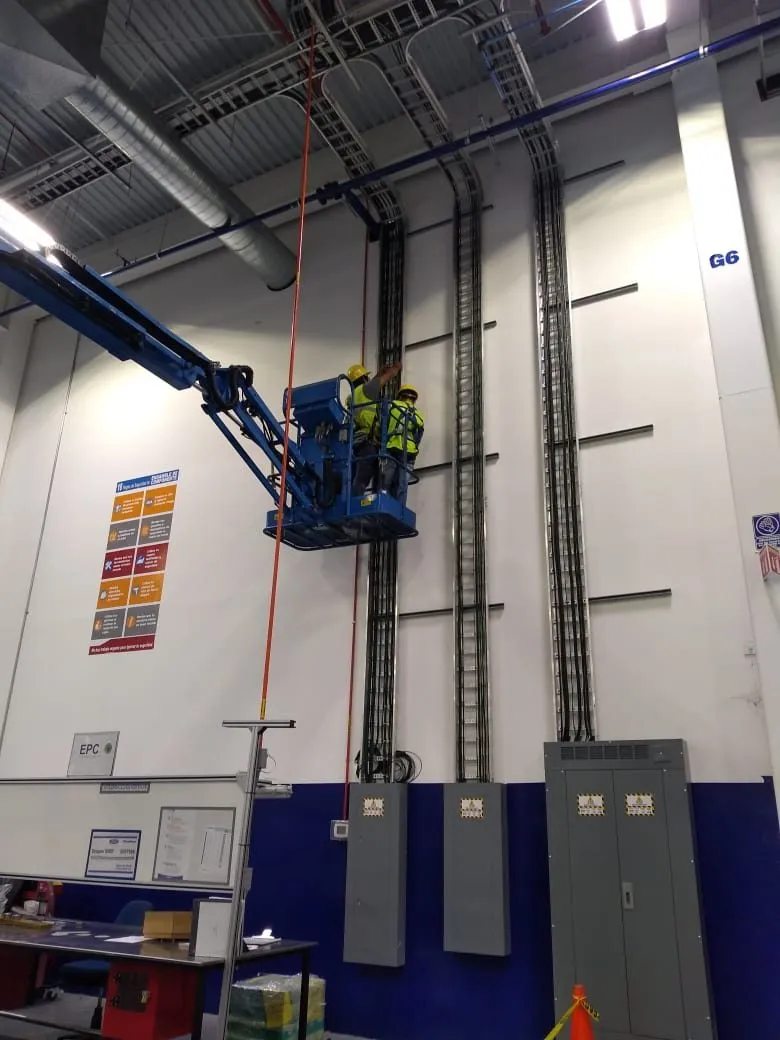 Canalización instalada a altura desde plataforma elevadora, con arnés y casco