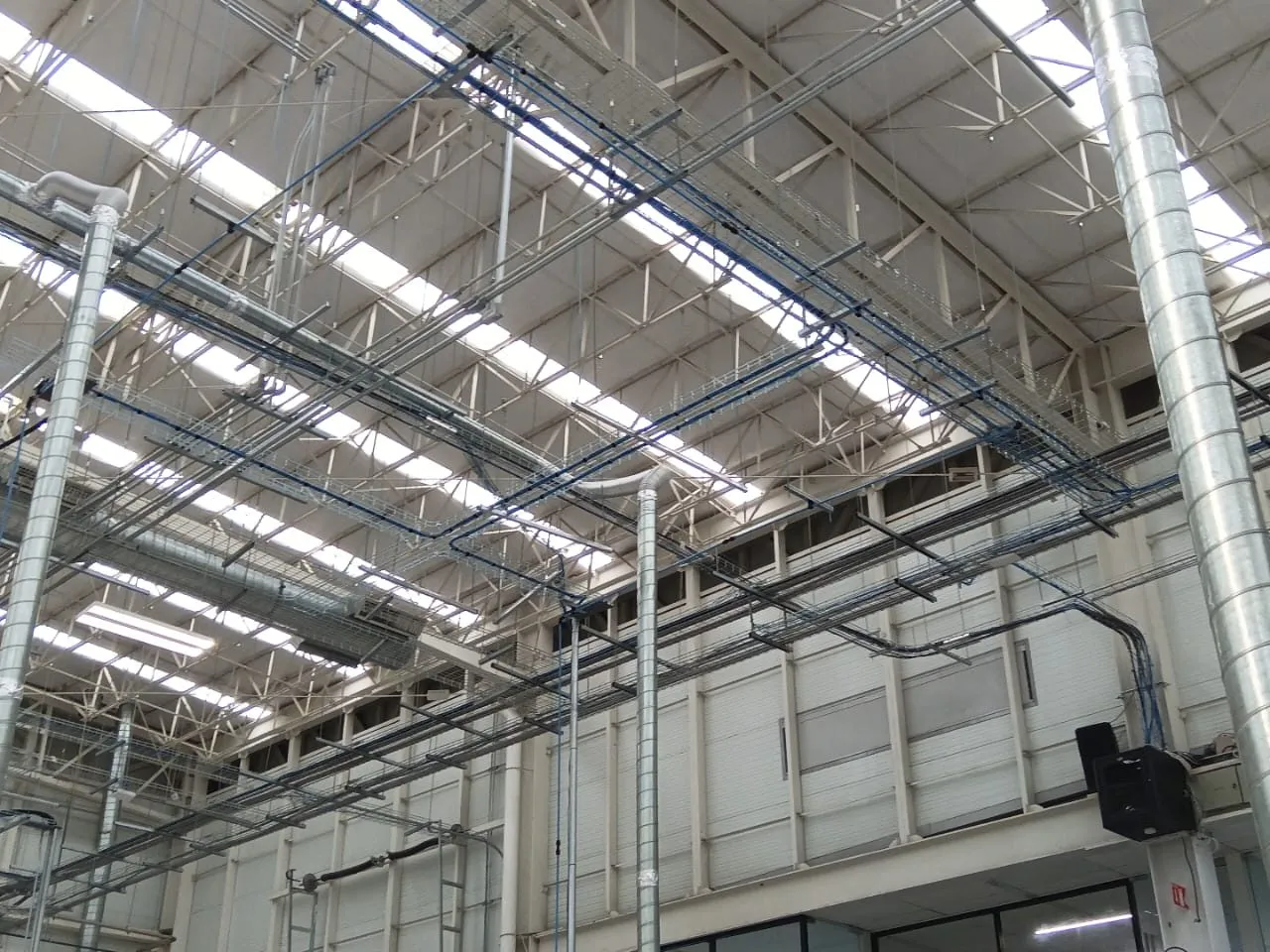 Charolas portacables, ductos y alumbrado montados en nave industrial